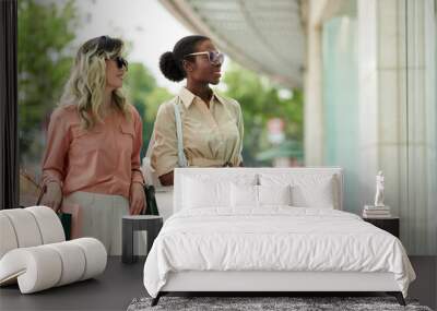 Fashionable young women with shopping bags standing at window of boutique Wall mural