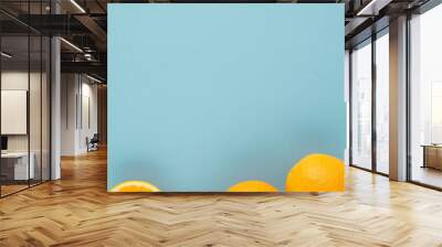 Fresh ripe juicy oranges on light blue background. Summer, harvest, vitamins concept Wall mural