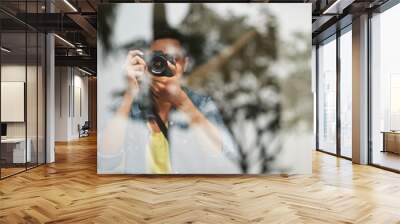 Man photographing something through glass with professional camera Wall mural