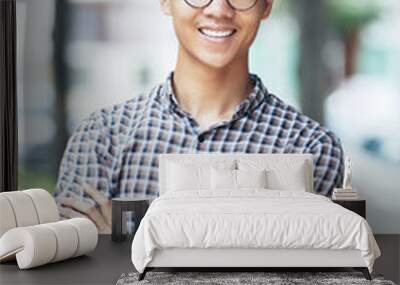 Portrait of happy smiling young man in glasses and plaid shirt crossing arms and looking at camera Wall mural