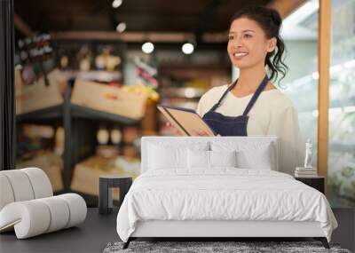 Portrait of positive grocery store worker with digital tablet Wall mural