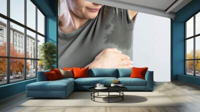 Young woman with hyperhidrosis sweating. Young woman with sweat stain on her clothes.. Wall mural