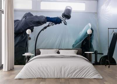 Car paint shop in a car service place. Close up photo of a male hand working to polish and paint the hood of a damaged car. Wall mural