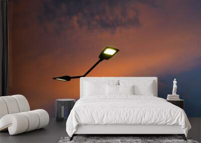 Public street lighting pole with LED lights with an amazing sunset color background. Wall mural