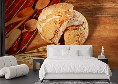 Slices of a delicious home made bread. Bread baking photo in a beautiful setup with ears of wheat in background. Fresh bread on the wooden counter top. View from above. Wall mural