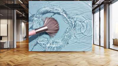 Makeup brush in clean water with a splash. Summer cosmetics concept. Top view. Wall mural