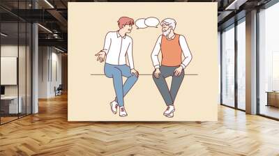 Old and young men sitting together talking. Older and younger male generation with speech bubbles engaged in conversation. Vector illustration.  Wall mural