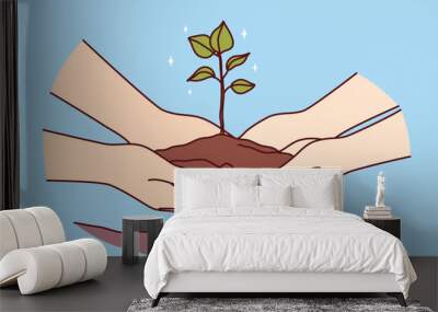 People hands with tree sprout in ground as metaphor for environmental activism and concern for nature. Two people plant tree together in ground in backyard, wanting to create scenic view from window. Wall mural