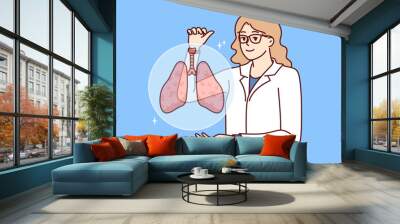 Woman doctor with smile demonstrates lungs of person offering to undergo medical examination of body. Medic in white coat recommends paying attention to lungs diseases bronchitis and tuberculosis Wall mural