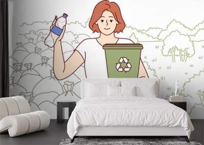 Woman ecologist calls for separate collection garbage and recycling of plastic bottles, holds bucket in hand. Girl ecologist dreams of closing garbage dump and restoring parks with beautiful nature. Wall mural