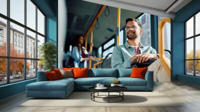 Below view of happy man commuting by public transport. Wall mural