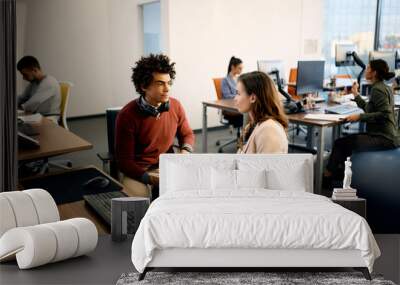 Black computer programmer and his colleague with disability cooperating while working at corporate office. Wall mural