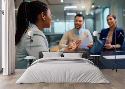 Black female financial advisor talks to couple during meeting in office. Wall mural