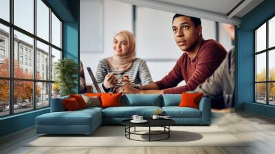 Black male student paying attention during class at university. Wall mural