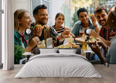 Cheerful friends enjoying in Mexican food in restaurant. Wall mural