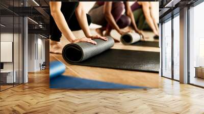 Close-up of athletic woman rolling up her exercise mat after practicing at health club. Wall mural