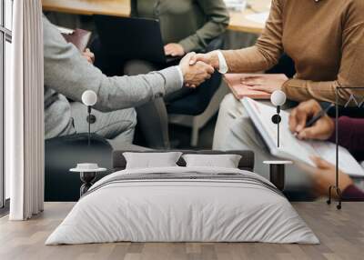 Close-up of coworkers shaking hands during business meeting in office. Wall mural