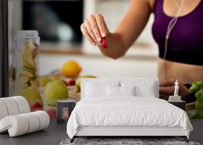 Close-up of female athlete eating fruit salad. Wall mural