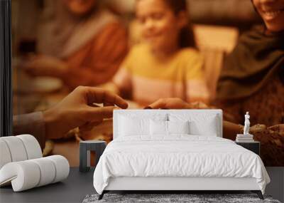 Close up of Muslim couple eat sesame for dessert at dining table. Wall mural