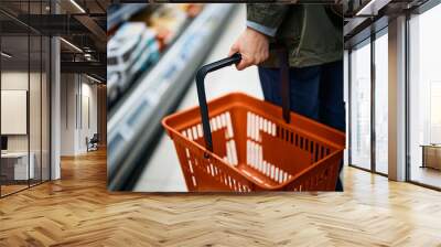 close-up of woman with empty shopping basket by diary aisle at grocery store. Wall mural