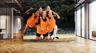 Female soccer players scream while celebrating after winning the match on stadium. Wall mural