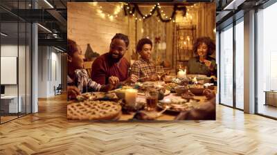 Happy African American extended family talking during Thanksgiving dinner at dining table. Wall mural