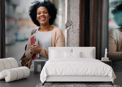 Happy African American mid adult student in front of the library. Wall mural