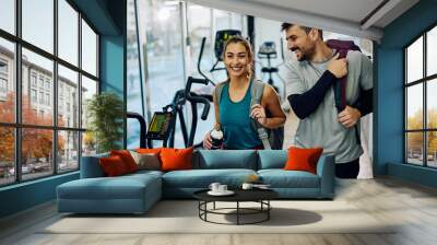 Happy athletic couple getting out of gym after sports training. Wall mural