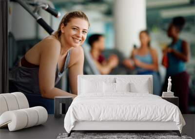 Happy athletic woman during sports training in gym looking at camera. Wall mural