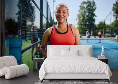 Happy black athlete playing pickleball with her friends and looking at camera. Wall mural