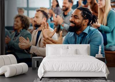 Happy black businessman applauding after successful conference in convention center. Wall mural