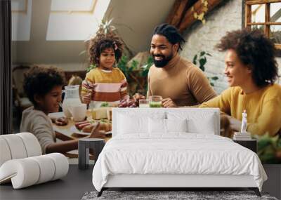 Happy black family enjoying in meal at dining table at home. Wall mural