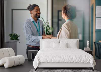 Happy black job candidate shaking hands with female CEO in office. Wall mural