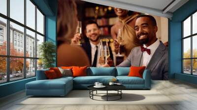 Happy black man toasting with friends while celebrating New Year. Wall mural