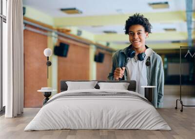 Happy black teenage boy in school hallway looking at camera. Wall mural