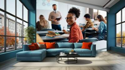 Happy black university student attending lecture in classroom and looking at camera. Wall mural