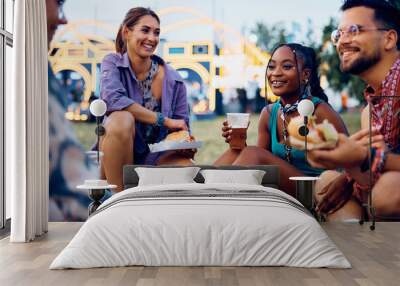 Happy black woman and her friends enjoying in beer and burgers during summer music festival. Wall mural