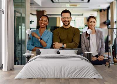 Happy business team in modern office looking at camera. Wall mural