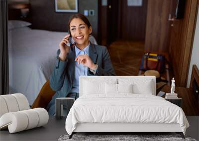 Happy businesswoman making  phone call in hotel room. Wall mural