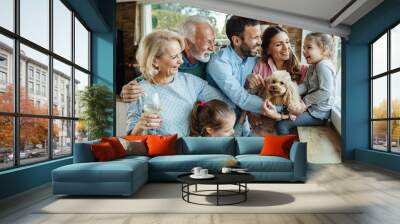 Happy extended family with a dog having fun at home. Wall mural