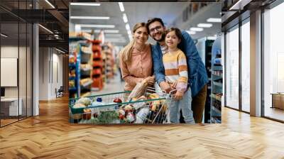 Happy family buying supermarket and looking at camera. Wall mural