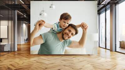 Happy father having fun while playing with his small son at home. Wall mural