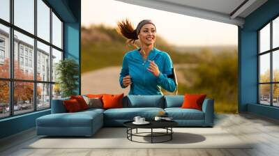 Happy female runner jogging in the morning in nature. Wall mural