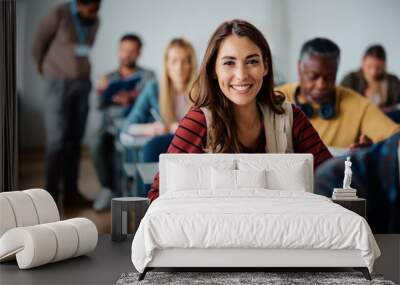 Happy female student learning in classroom and looking at camera. Wall mural