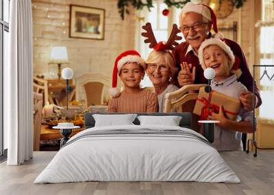 Happy grandparents with grandkids celebrate Christmas at home and look at camera. Wall mural