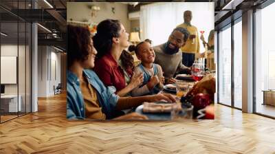 Happy multiracial extended family has fun and laughs while gathering for Thanksgiving in dining room. Wall mural