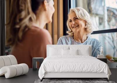 Happy senior woman enjoys in conversation with her adult daughter in cafe. Wall mural