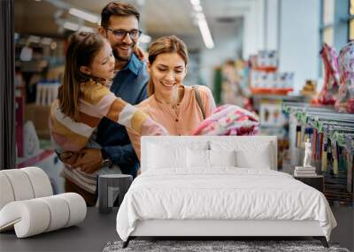 Little girl and her parents choosing backpack for school while shopping in store together. Wall mural