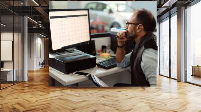 Manager of car service shop working on a computer in the office. Wall mural