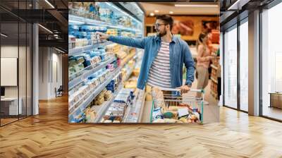 Mid adult man shopping food in supermarket. Wall mural